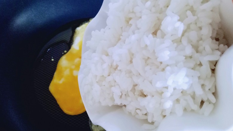 虾仁黄金炒饭,将熟米饭倒入锅中。