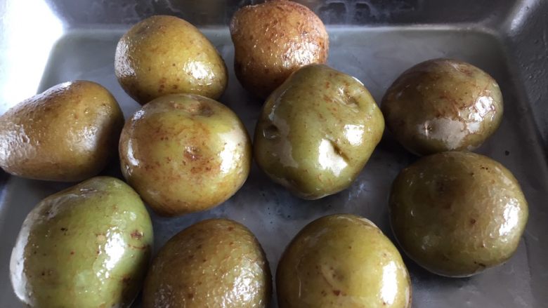 意式烤小土豆,把煮熟的小土豆入烤盘，把橄榄油摸匀每个小土豆。
