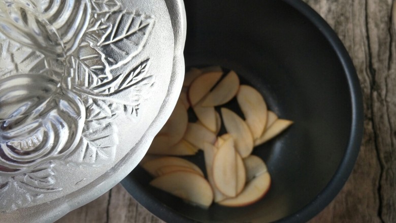 七夕玫瑰花苹果派,苹果片放入锅中倒入适量的清水。