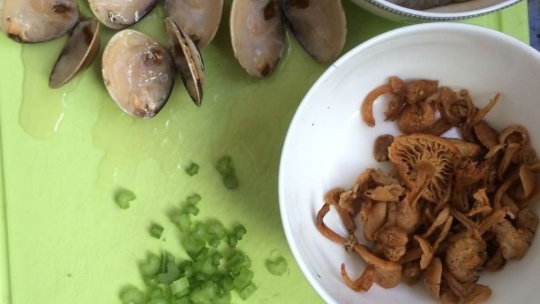 文蛤虾仁海鲜粥,将文蛤对半切开（我的文蛤是放冰箱冷冻的所以需要切开，如果是新鲜的文蛤可忽略这一步），芹菜切小丁，姜切丝，鸡针菇泡开，备用。
