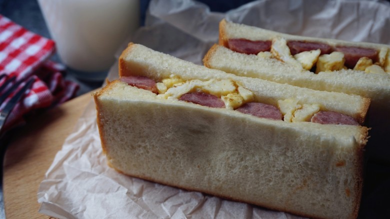 香肠鸡蛋三明治,配上一杯牛奶，营养丰富的早餐。