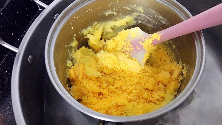 金沙奶黄馅（为月饼季而准备）,此时面糊中的水分会慢慢收干，有点耐心继续炒，炒到面糊成团时，加入过筛后的咸蛋黄。