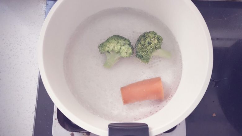 奶香玉米浓汤 宝宝辅食,锅里烧水，水开后将洗净的胡萝卜和西兰花倒入锅中