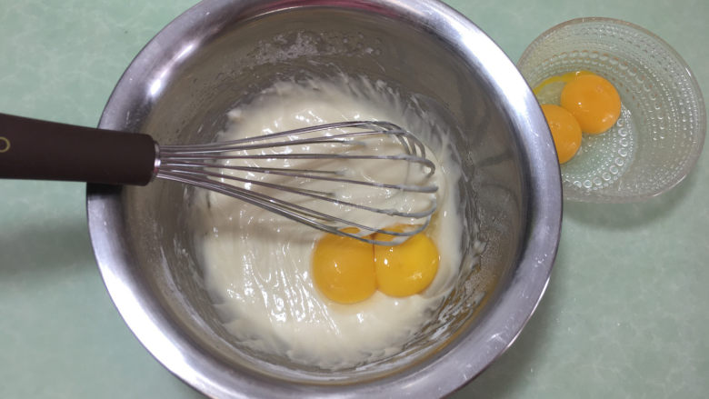 形彩绘芒果蛋糕卷,蛋黄分两次加入混合的面粉糊中，搅拌均匀后再加下剩下的两个蛋黄。