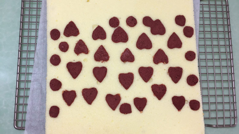 形彩绘芒果蛋糕卷,然后拿去模具和彩绘硅垫，表面再盖一张油纸，将蛋糕翻面晾凉。