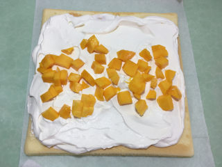 形彩绘芒果蛋糕卷,蛋糕晾凉后在没有花纹的一面上涂抹上奶油，中间铺上芒果丁。