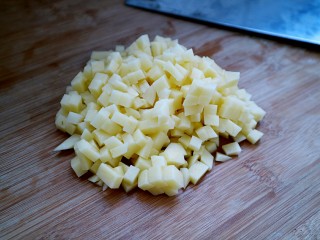 土豆培根炒米饭,土豆洗净削皮切成小丁。