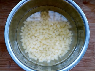 土豆培根炒米饭,把切好的土豆丁放入清水里，防止氧化。