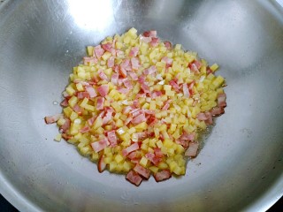 土豆培根炒米饭,加入土豆丁翻炒均匀。