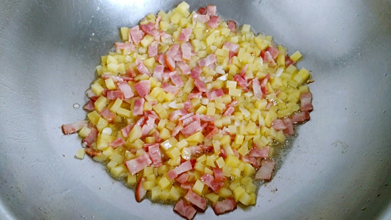 土豆培根炒米饭,加入土豆丁翻炒均匀。