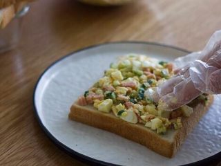快手美味鸡蛋三明治,取一个面包片，把馅料放在上面，压实以后再加一层。可以加上喜欢的生菜。
