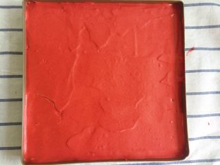 覆盆子红丝绒蛋糕,用刮刀将面糊抹平后，提起烤盘高于台面20厘米震盘，震掉大气泡