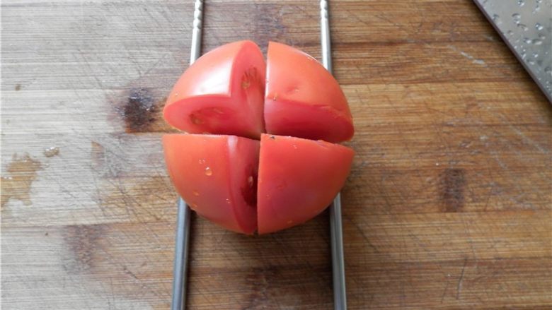 莲花番茄,将一个<a style='color:red;display:inline-block;' href='/shicai/ 59'>番茄</a>洗净竖起来，旁边放二根筷子，先横竖各切一刀。