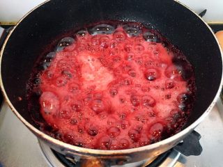 覆盆子红丝绒蛋糕,制作覆盆子玫瑰奶油，将覆盆子，柠檬汁，和细砂糖用奶锅加热至沸腾，煮到接近果酱状态
