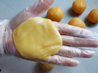 广式月饼~金沙奶黄馅儿,14．取一个月饼皮，在手心按成圆形的皮，大小以能包的住馅料为准。