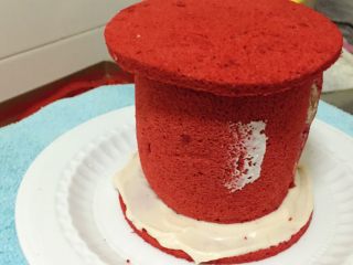 覆盆子红丝绒蛋糕,将覆盆子玫瑰蛋糕卷顶端抹奶油，加果酱完成基础抹面后加盖另一个6寸蛋糕片，做到上下蛋糕片位置一致