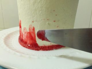 覆盆子红丝绒蛋糕,取出冷藏定型好的蛋糕体，用小抹刀在蛋糕底部涂少量果酱，用抹刀在蛋糕上轻轻向上抹，不要来回反复涂，做到一刀是一笔，如果觉得颜色不够就在原来位置在抹一遍