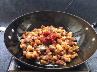 土豆炖牛腩,添加两勺红油豆瓣酱、生抽同炒，让牛肉与调料味道融合。