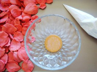 国色天香立体饼干,糖霜装入裱花袋，取一个饼干做花朵底托，放入小碗中（利用小碗的弧度支撑花朵，制作花瓣的时候可顺便做几个底托哦。）