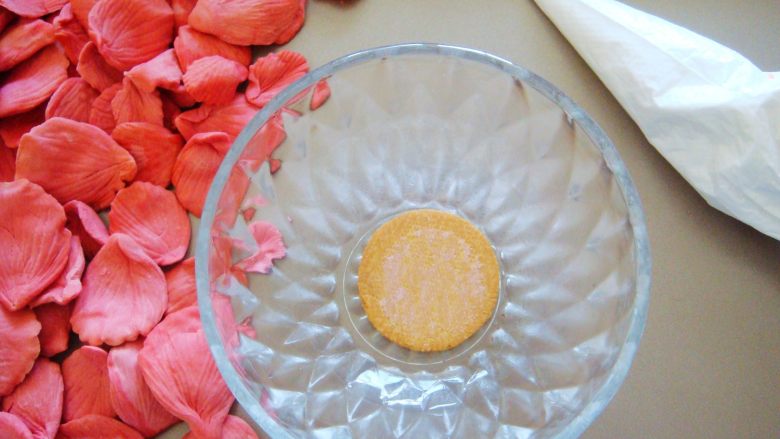 国色天香立体饼干,糖霜装入裱花袋，取一个饼干做花朵底托，放入小碗中（利用小碗的弧度支撑花朵，制作花瓣的时候可顺便做几个底托哦。）