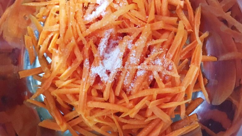 洋芋（土豆）胡萝卜擦擦,把胡萝卜丝放到容器里 撒一小勺盐腌上10分钟