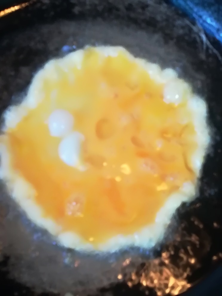 葱爆海螺,先将鸡蛋放入锅里煎