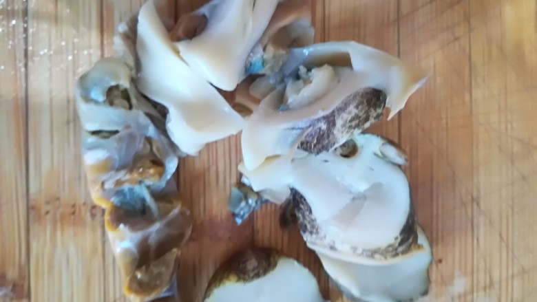 葱爆海螺,将海螺肉放菜板用刀切成片
