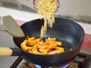 私房酱汁闷虾,待姜蒜味起来后，倒入煮熟的黄豆，一起翻炒。