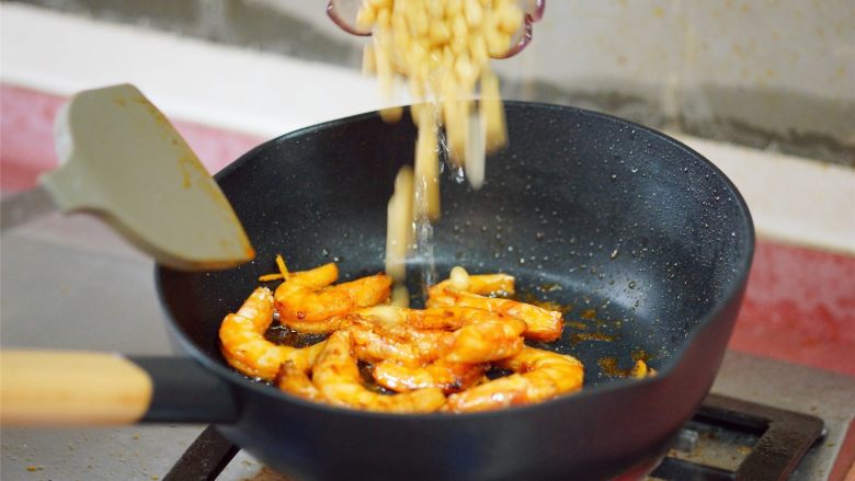 私房酱汁闷虾,待姜蒜味起来后，倒入煮熟的黄豆，一起翻炒。