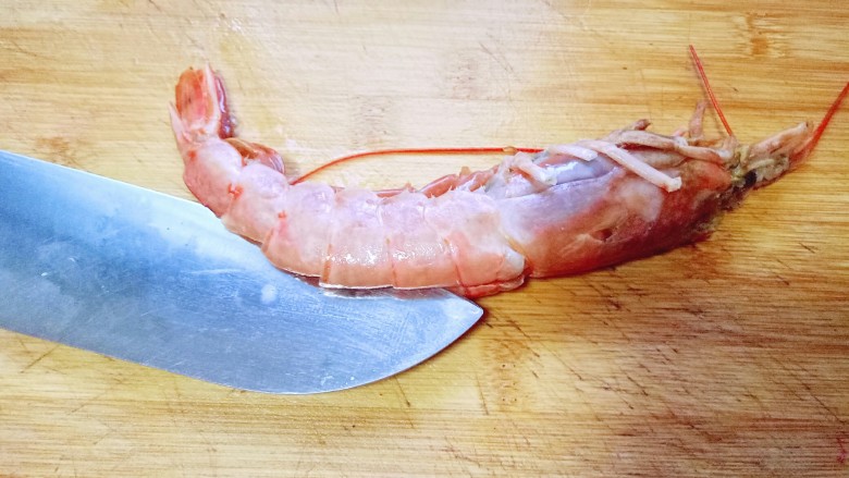 土豆泥芝士焗阿根廷红虾,用刀从虾的背部将虾肉切开，取出虾线，和虾头的脏物。依次做完，用冷水冲洗干净，淋干水份。