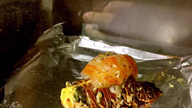 烤澳州龙虾尾配海鲜馅料,烤箱预热，将刷好烤料的虾放入烤箱。中火200度，20分钟。