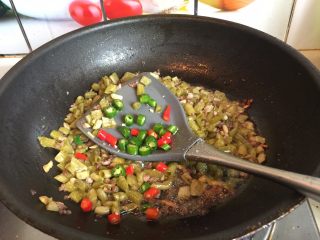 酸豆角炒肉末,最后加入切好的青、红辣椒丁炒匀，出锅前加点鸡粉即可