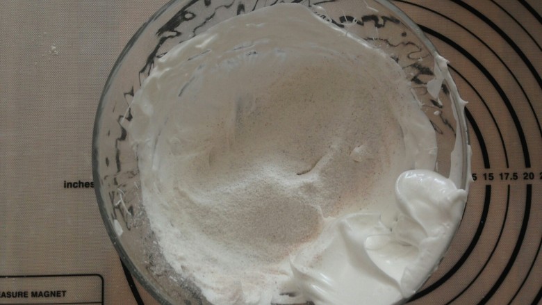 面粉版马卡龙,将面粉混合物和糖粉的1/3，筛入到打发好的蛋白霜里，利用切拌的手法混合均匀。
