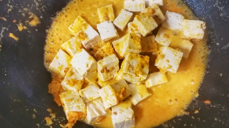 蟹黄味的咸蛋黄烧豆腐,加入小半碗清水，水开后小火炖两分钟。
