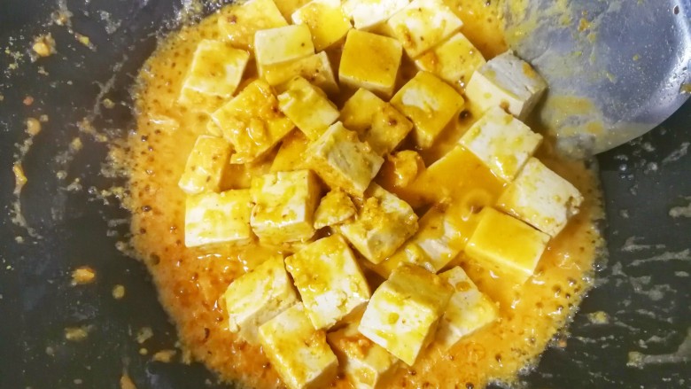 蟹黄味的咸蛋黄烧豆腐,放入适量的食盐，加入刚才调好的水淀粉勾芡，
