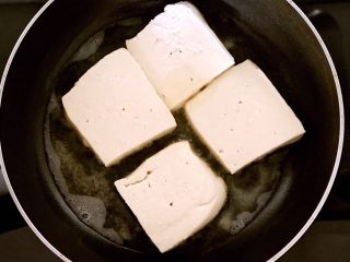 ＃吃豆腐＃鱼香豆腐,锅内加入大豆色拉油烧5分热，加入蘸好面粉的豆腐块，温火煎制