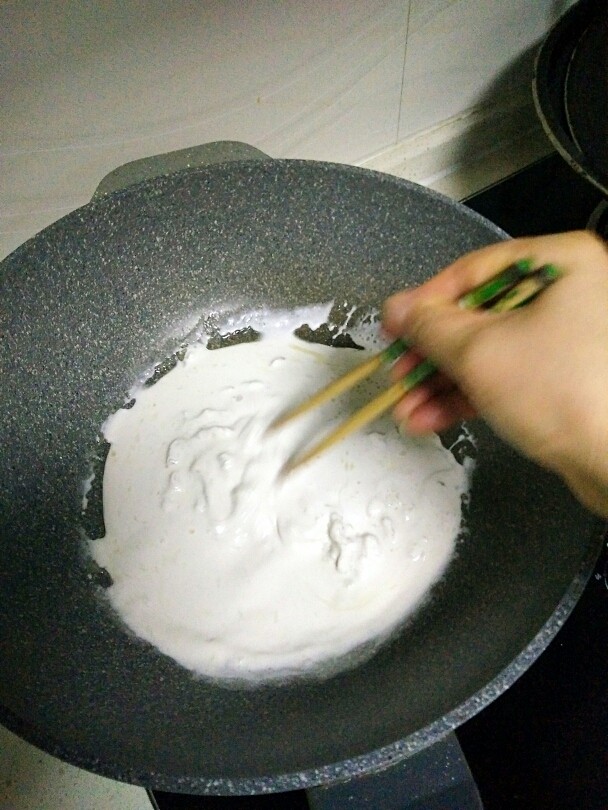 苕粉肉,用筷子在锅里快速转圈搅拌，使苕粉液慢慢成团。