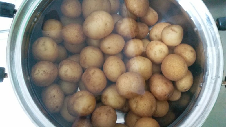 万能的土豆+飘香小土豆,煮好的土豆把锅里的热水倒掉，用冷水泡着，这样土豆会比较好剥皮