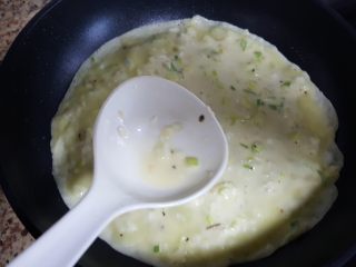 五分钟快手早餐~葱花鸡蛋饼,8．油热后，在锅中放入两勺鸡蛋面糊。