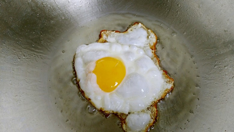 糖醋荷包蛋,待荷包蛋边缘煎至金黄色翻面，继续煎至两面金黄。