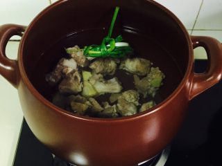 坤博砂锅排骨莲藕汤,入适量清水 下清洗干净的排骨，放两三片生姜  葱不用切 绕在一起就可以了