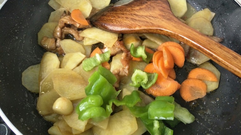 闷汁土豆片,加入胡萝卜和青椒继续翻炒一分钟