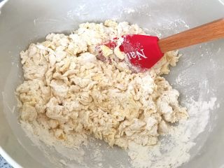 牛角可颂,将面粉一点儿点儿加入，轻轻的揉匀，不要过于用力搅拌（以免起面筋），根据面团的情况，来选择是否再加水