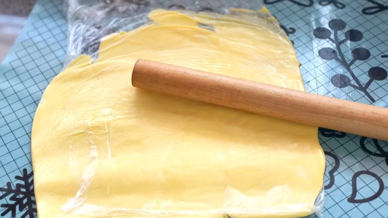 牛角可颂,从冰箱里拿出冷藏黄油，放到保鲜袋里用擀面杖擀开合适宽度。