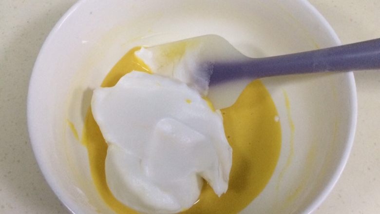 百香果慕斯,取1/3蛋白糊加入蛋黄液中，用刮刀翻拌均匀。