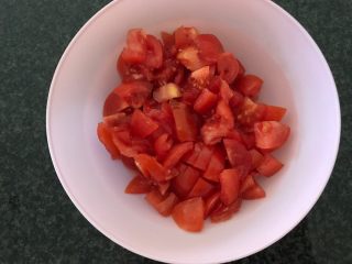 西红柿淋金蒜粉丝,然后我们开始切西红柿，切成小块装碗备用，