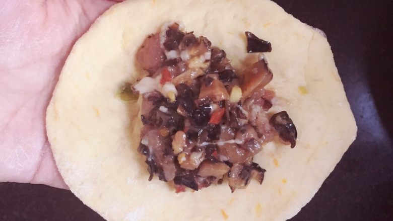 南瓜香菇肉包🎃,用擀面杖把小面团擀成中间厚，边上薄的圆形面饼，取一张面饼放入适量的肉馅