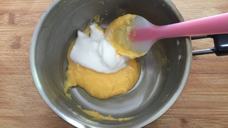 舒芙蕾,将三分之一蛋白跟蛋黄牛奶糊翻拌均匀；