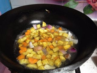 快手咖喱土豆炖牛肉,倒入土豆丁和胡萝卜丁，加适量水煮开