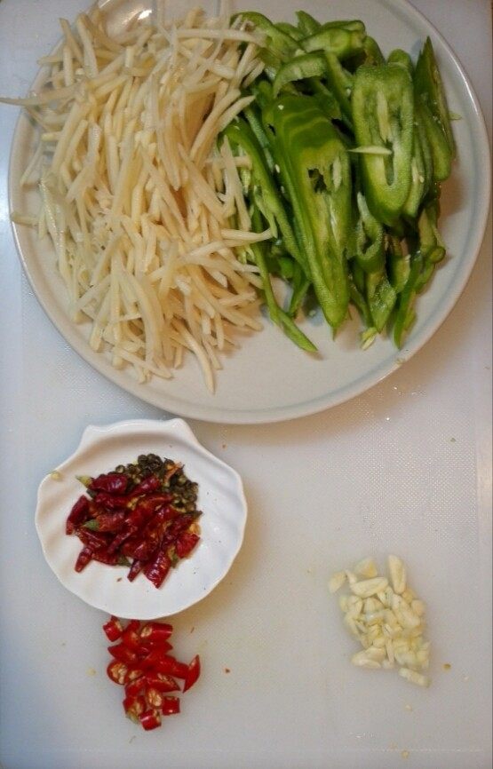 青椒土豆丝,改刀切丝，干红辣椒剪成段，大蒜切片